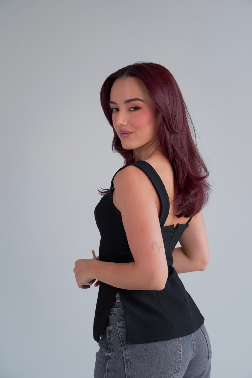 Looking back over her shoulder in a black corset top